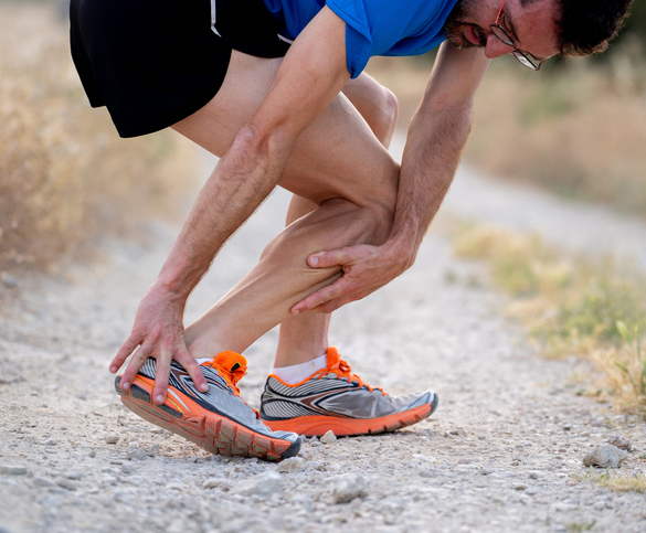 close up of runner touching painful twisted or broken ankle shin or calf athlete runner training accident sport running ankle sprain concept Stress Fractures in Orange County