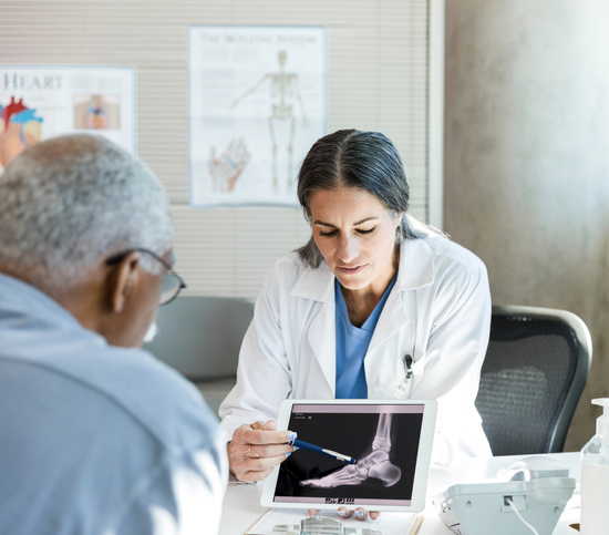 Orthopedist discusses senior patient's foot x-ray Digital X Rays in Orange County